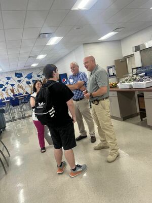 Deputy County Clerk Suzanne Smith, County Clerk Mike Corey and Sheriff Mike Smith speak with a student during their visit.